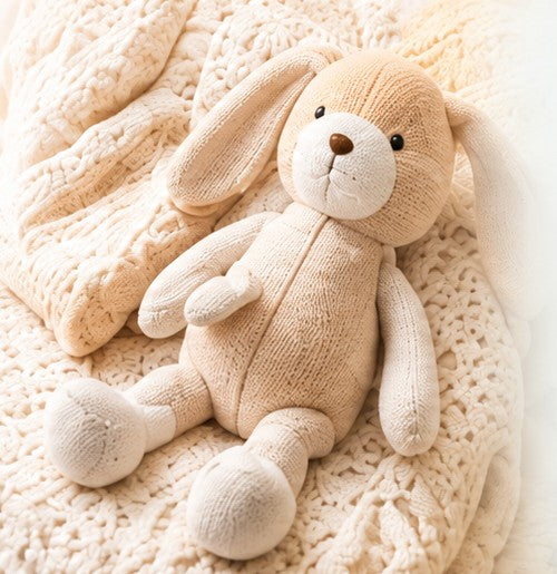Conejo de peluche tejido sobre una manta de algodón